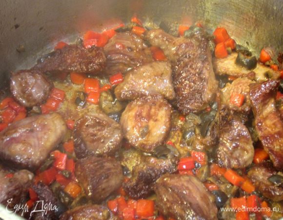 Убавьте огонь до среднего. Выложите оливки, сладкий перец, щепотку тимьяна и перемешайте.
Через пару минут полейте мясо соком половины лимона и 100 мл кипятка. Посыпьте сахаром. Уменьшите огонь до маленького. Перемешайте мясо и тушите около пяти минут. Блюдо готово.