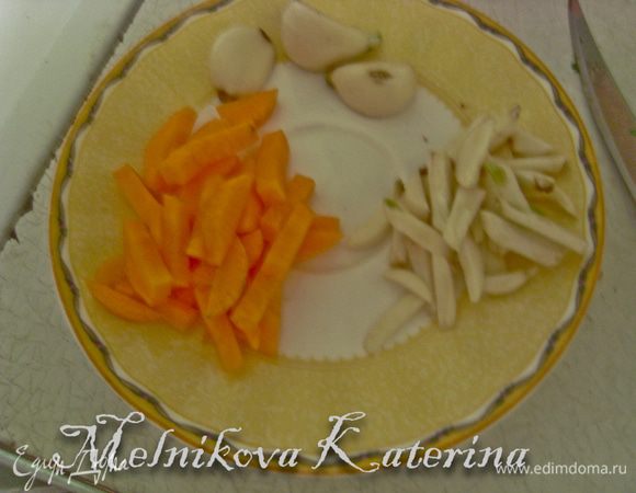 Нарезать морковь на кружочки, а затем каждый кружок на полоски. Также нарезать на полоски чеснок. 