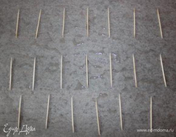 На столе раскладываем пекарскую бумагу, смазанную растительным маслом. Раскладываем шпажки на расстоянии.