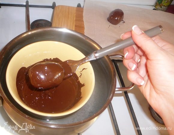 Каждый шарик опускаем в шоколад и, как только он полностью будет покрыт тонким слоем, с помощью вилки аккуратно переносим на лист фольги или пекарской бумаги.