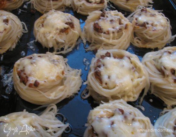 Дальше все еще проще.В кипящую, подсоленную воду "кидаем" наши гнезда.Желательно в один слой чтобы лежали на дне кастрюли.Можно добавить 1ст ложку растительного масла,чтобы не слипались.Варим 5мин после чего достаем шумовкой и выкладываем на смазанный маслом противень.Во внутрь кладем начинку и посыпаем тертым сыром.В разогретую духовку отправляем минут на 5 только для того,чтобы сыр расплавился.