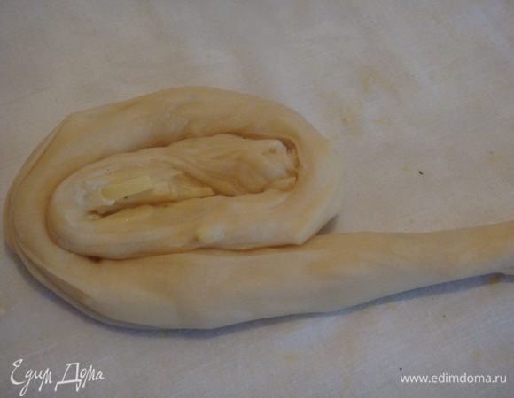 Затем начиная от края к середине по кругу закручиваем картофель в тесто, делаем рулетики.