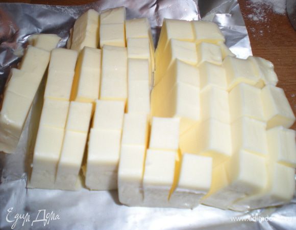 Масло нарежьте кубиками и оставьте на упаковочной бумаге. Бумагу не выбрасывайте, ей удобно смазывать формы.