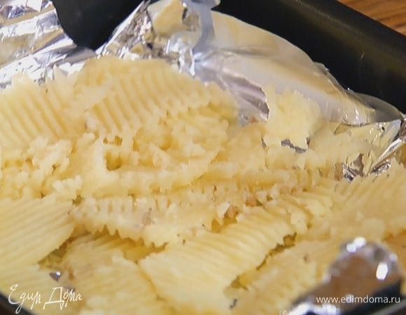 Небольшой противень выстелить фольгой, разложить картофель так, чтобы получился пласт, и сбрызнуть оливковым маслом.