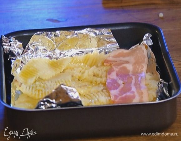 На картофель выложить бекон и отправить в разогретую духовку на 10–15 минут.