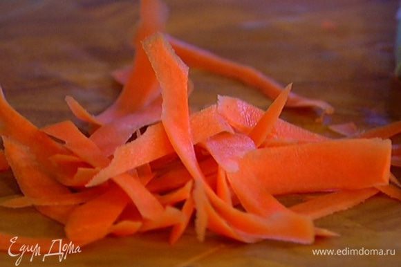 Морковь почистить и нарезать длинными тонкими полосками (можно воспользоваться овощечисткой).