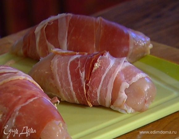 Куриные грудки надрезать сбоку, не прорезая до конца, чтобы получился карман. Поместить внутрь рикотту с песто, затем обернуть каждую грудку 2–3 кусками ветчины.