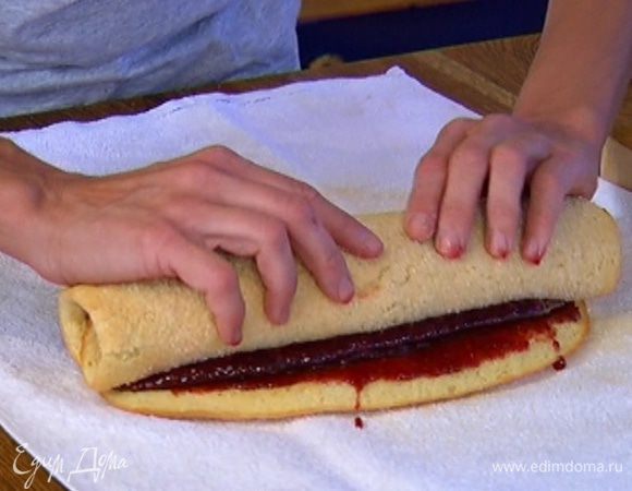 Выложить на полотенце испеченный корж, смазать его вареньем и плотно скатать в рулет. Дать ему остыть прямо на полотенце.