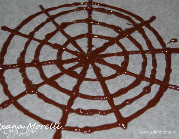 Для того чтобы приготовить паутинку растопите черный шоколад на водяной бане и корнетиком нарусуйте паутинку на заранее приготовленном листе бумаги для выпечки. Дать полностью застыть. Затем положить паутинку из шоколада на поверхность торта и обильно присыпать какао-порошком.  