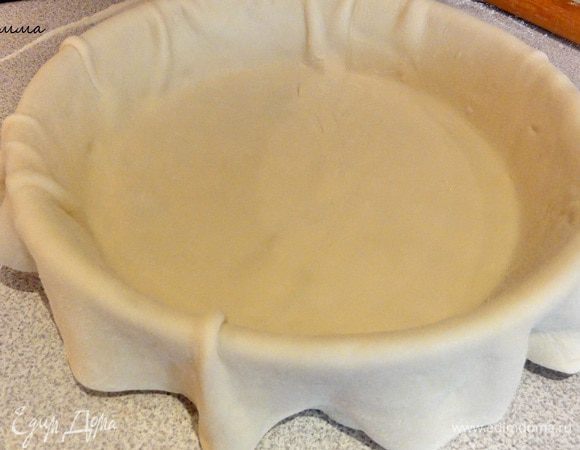 Раскатайте большую часть теста толщиной 3 мм, выложите в форму так, чтобы края теста свисали.