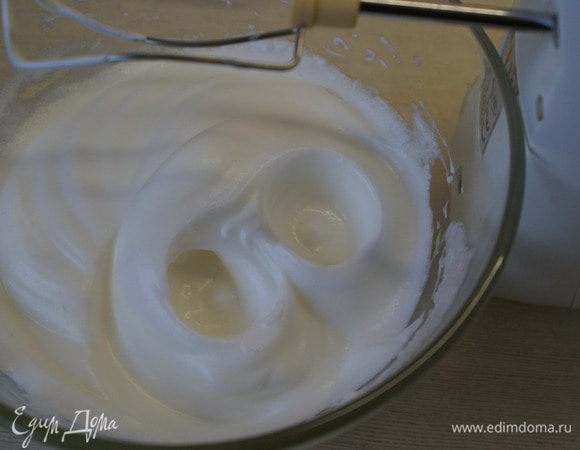 Затем добавьте половину сахара (30 г) и продолжайте взбивать, пока сахар не растворится, а масса не станет гладкой и блестящей. 
