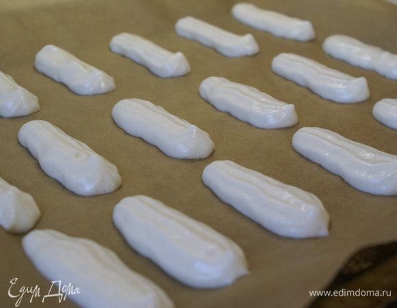 Переложите тесто в кондитерский мешок или плотный пакет и отсадите на противень, застеленный бумагой для выпечки в виде палочек длиной 10-12 см.