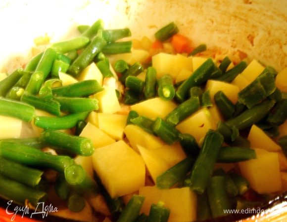 Добавить в кастрюлю фасоль, картофель и бульон. Накрыть кастрюлю крышкой и убавить огонь. Варить 10–15 минут.