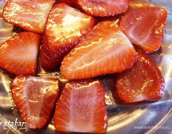 Выложить ломтики клубники на плоскую тарелку, посыпать их сахаром и поставить в микроволновку на 30 секунд при мощности 300. Достать из СВЧ и поставить охлаждаться. 