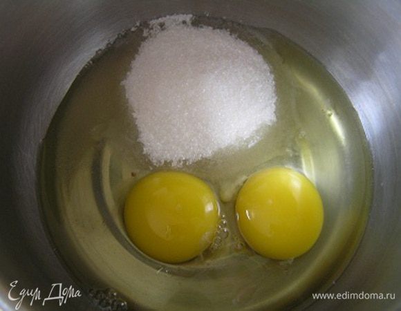 Смешать яйца и сахар в небольшой кастрюльке с толстым дном (при нагревании сахар не даст яйцам свернуться).
