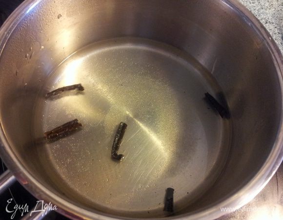 В сотейник наливаем воду, сахар и на маленьком огне растапливаем. 
Палочку ванили режем на кусочки и удаляем семена.( кладем в сторону), а кусочки добавляем в сахарный сироп и варим минуты три. Тем временем...