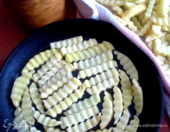 После курицы у меня духовка горячая,поэтому жарить будем в ней.Распределяем равномерно по дну сковороды,налив масло до половины высоты картошки.Солим крупной солью.