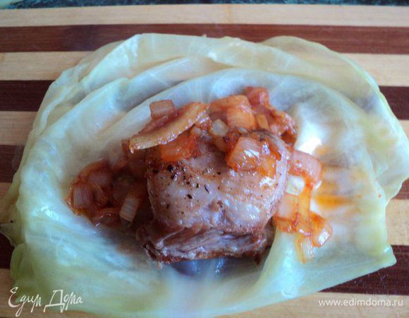 На лист капусты положить ребрышко, сверху ложку пассерованного лука 