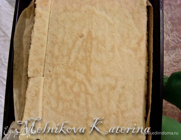 Бисквит разрезать пополам. Выложить одну часть бисквита в форму, выстеленную бумагой (где будет формироваться пирожное, это может быть и круглая разъемная форма, либо рамка для выпечки). 