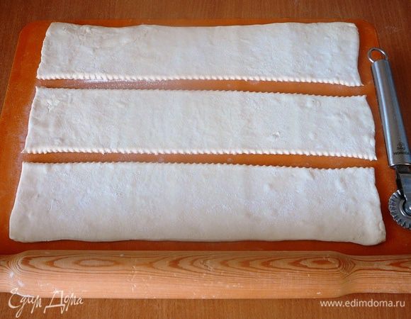 Тесто слегка раскатать. Разрезать вдоль на три полоски, одинаковые по ширине.