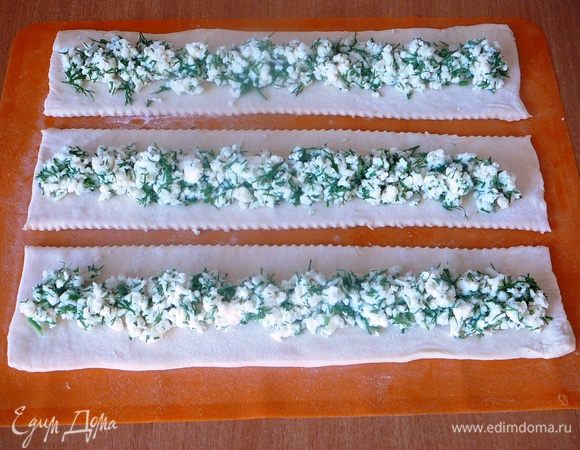 По центру полоски выложить сырную начинку 