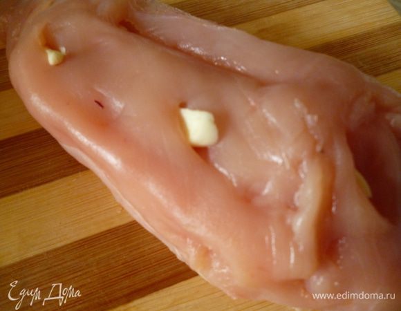 Шпигуем чесноком.По всей поверхности мяса делаем ножом надрезы под углом и вставляем туда кусочки чеснока.Так же поступаем и со вторым куском.