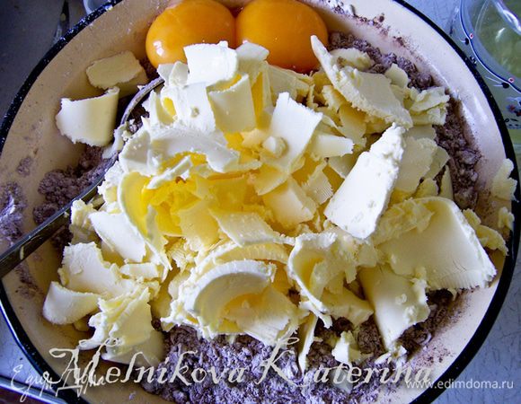 Отделить желтки от белков, добавить к мучной смеси желтки. Масло нарезать и добавить к смеси. 