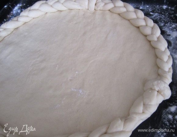 Край теста смочить водой. Положить косичку.