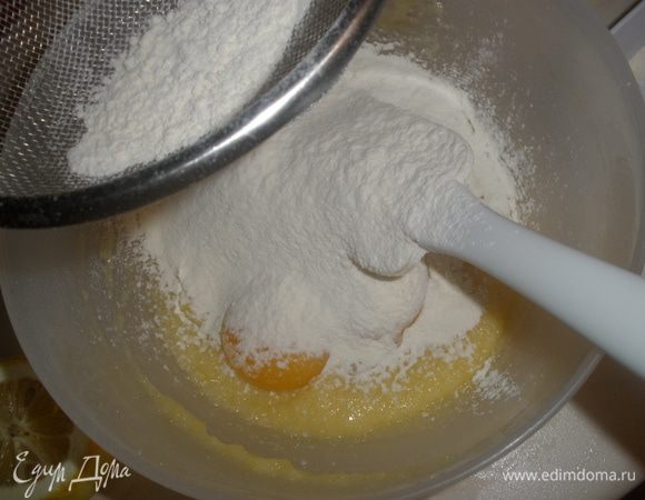 Ввести в маслянно-сахарную смесь муку с разрыхлителем. Добавить желтки. Растереть до однородности. Смесь напоминает пасту. 