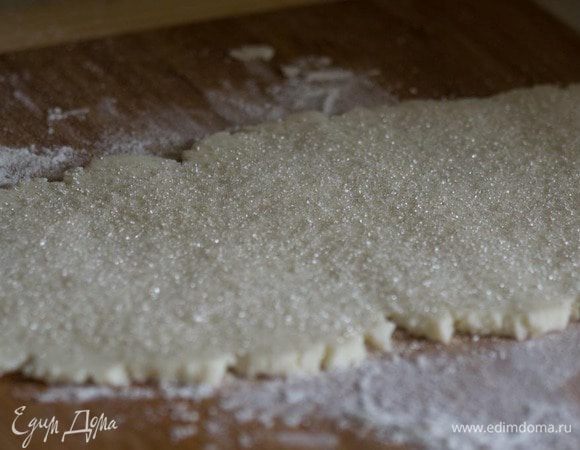 Разделить тесто на две части. Каждую раскатать и посыпать по 1 ст. ложке сахара