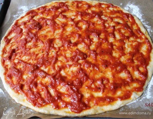 Выкладываем тесто на хорошенько подпылённую мукой поверхность и кулаками растягиваем его до нужного размера и формы (в данном случае хватило силы пальцев), толщина должна быть примерно 0,3-0,5 см. Перекладываем тесто на лист (я кладу пекарскую бумагу и присыпаю мукой), смазываем тесто оливковым маслом (1 ст.л.), сверху распределяем томатный соус, отступив от края 1 см. 