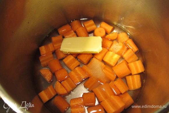 Положите морковь в сотейник. Залейте морковь водой, чтобы она не до конца прикрывала ее. Положите туда половину масла, сахар и соль. Поставьте на средний огонь.