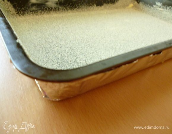 Форму для выпечки обернуть двумя-тремя слоями фольги, чтобы бисквит не поднимался горкой и не подгорали бока. Форму выстлать бумагой для выпечки или, как у меня, смазать холодным сливочным маслом и посыпать манкой. Вылить тесто и разровнять верх (забыла сделать фото). У меня прямоугольная форма 20х30см.