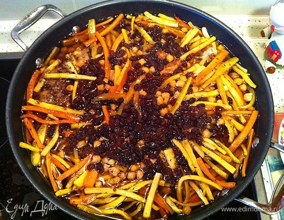 Когда пройдет указанное время, нужно вынуть из Вок чеснок и перец, разровнять морковь, сверху добавить изюм (промытый). 