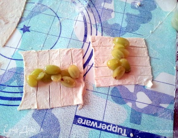 По двум противоположным сторонам каждого квадрата сделать поперечные надрезы шириной 1.5см и длиной 4см. В центр положить 1,5-2 ст.л. виноградной начинки.