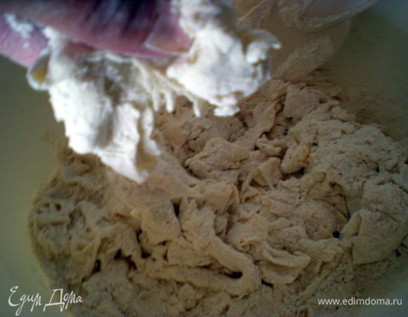 В большую миску всыпать всю муку. К ней добавить закваску, разрывая её руками на кусочки и смешивая с мукой.