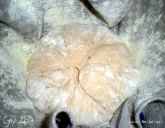 Тесто выложить на стол, разделить на две части. Из каждого куска сформировать шар. Миски хорошо присыпать мукой и положить шары из теста гладкой стороной вниз, швом вверх.