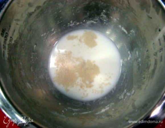 В большой ёмкости смешать воду и молоко (их температура не должна быть выше 26°С) с сахаром и дрожжами.
