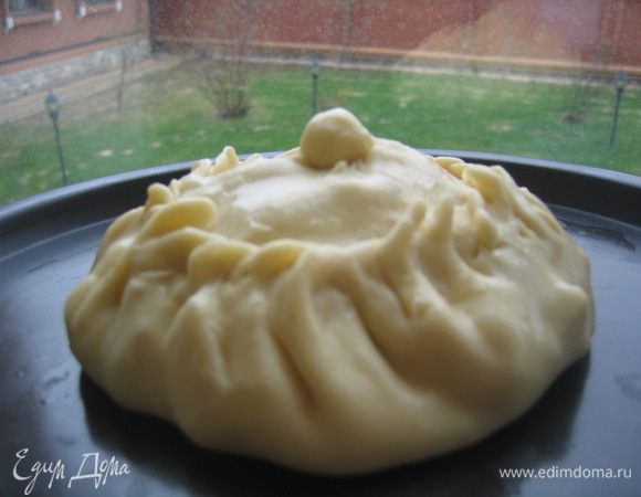 Готовим элеш. Оставшееся тесто (или три шарика) еще раз подмесить, отделить от него 1/4 часть для верхней крышечки и колобка. Большую часть теста раскатать в круг, положить сразу в форму (можно и плоский противень), выложить в центр начинку высокой горкой, приподнять края теста и защипить по всей окружности, оставив верхушку открытой. 1/4 часть теста также раскатать и накрыть пирожок сверху. Защипить края по кругу, сделать маленькое отверстие в центре и положить колобочек.