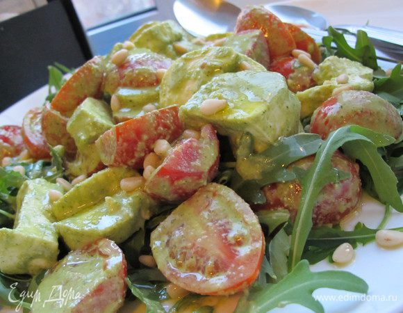 Нарезаем помидорки пополам, моцарелу (у меня в виде колбаски) сначала вдоль, а потом на кусочки. В блендере взбиваем все ингредиенты для соуса. Я добавляю немного воды, тогда он становится легким и воздушным. Добавляем соус к помидорам и моцареле (количество соуса регулируйте сами, в зависимости от вкуса), тщательно перемешиваем. На большое блюдо выложить рукколу, сверху выкладываем салат и присыпаем кедровыми орешками. 