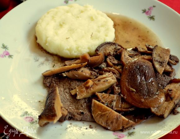 Уберем чеснок из сковороды, выливаем вино и бульон.Готовим на сред.огне.Соус должен уварится. Помешиваем.Добавляем грибы.Подаем на стол с готовой говядиной.