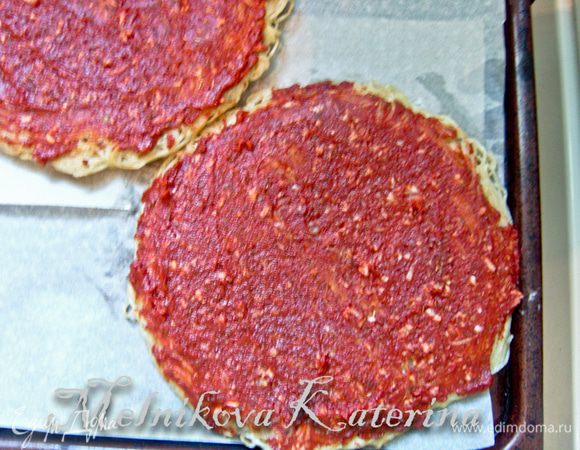 Застелить противень пекарской бумагой, выложить обе основы. Смазать их томатным соусом. 