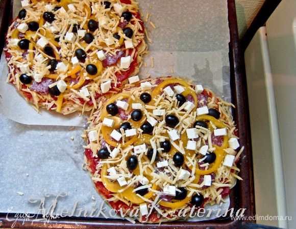 Выложить салями, перец, оливки. Присыпать сверху слегка сыром. 