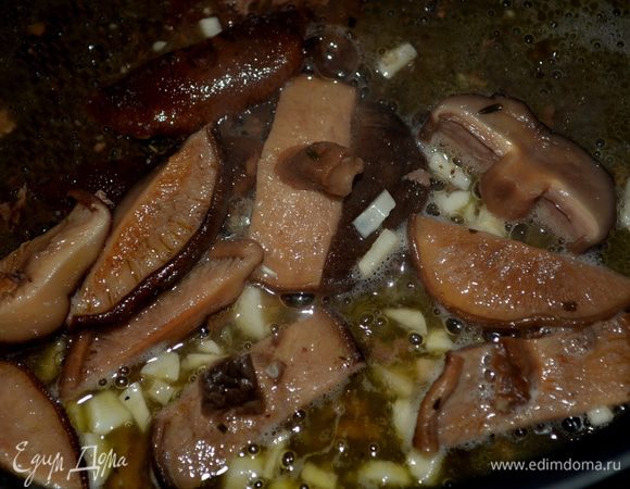 Добавим в это время на сковороду масло ,убавим огонь.Выложим чеснок и готовим его минутку или  как появится запах,выкладываем наши готовые шиитаке.Мешаем и пожариваем с чесноком примерно еще 1-2мин.Затем добавляем вино и курин.бульон.