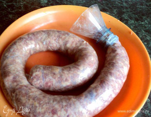 Кишки, если они не чищенные, необходимо почистить. Для чего их необходимо вывернуть и положить на 30 мин в воду, в которую добавить 1/2ст.ложки соли и 1/2ст.ложки соды. Затем хорошо почистить тупой стороной ножа на деревянной доске. Промыть и положить на 5 мин в слабый раствор марганцовки, что бы исчез розоватый цвет кишок, затем еще раз промыть и слегка посолить. Начинять колбасу можно использую специальную насадку к мясорубке или, как я,  обрезанную часть пластиковой бутылки в виде воронки.  Одеть на нее кишку, край завязать ниткой.Начинить не очень плотно колбасу через воронку, завязать края ниткой.                           