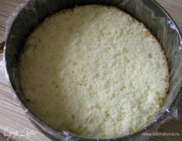Застелить разъемную форму для торта пищевой пленкой, на дно выложить бисквитный корж.