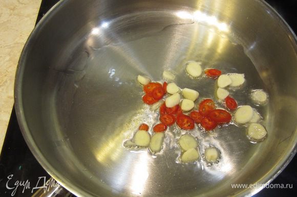 Теперь поставьте сковороду с растительным маслом на огонь выше среднего. После того, как масло нагреется - бросьте туда острый перец и чеснок.