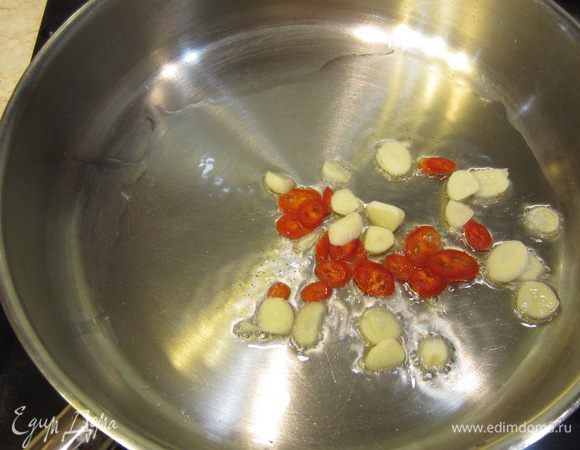 Теперь поставьте сковороду с растительным маслом на огонь выше среднего. После того, как масло нагреется - бросьте туда острый перец и чеснок.