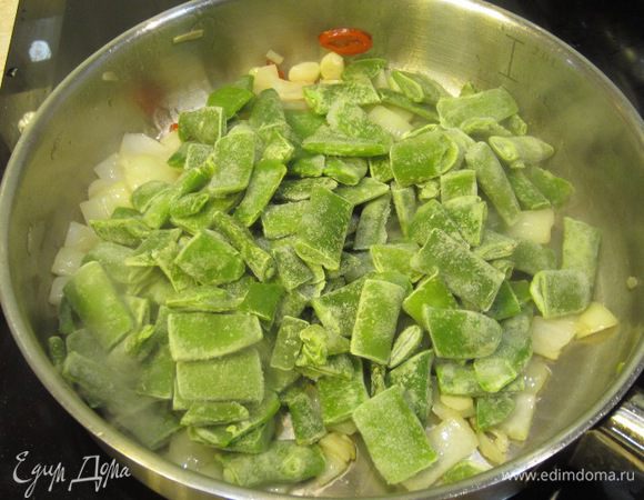 Положите замороженную стручковую фасоль. Посолите блюдо. Плесните немного воды и накройте крышкой. Держите под крышкой около трех минут. Задача этого этапа - прогреть фасоль.