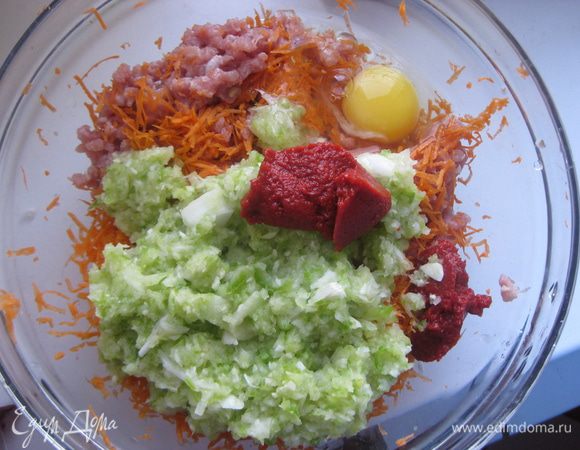 Кабачок натираем на терке с крупными отверстиями, морковь - на мелкой терке, лук мелко рубим. Добавляем овощи к мясному фаршу, также добавляет томатную пасту.